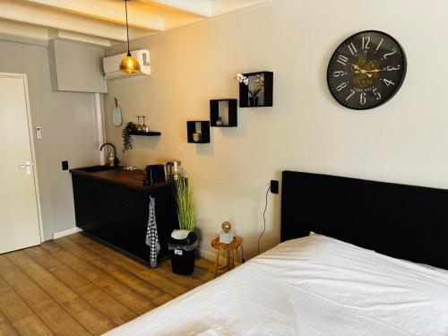a bedroom with a bed and a clock on the wall at Stadshotel DE ACADEMIE in Franeker