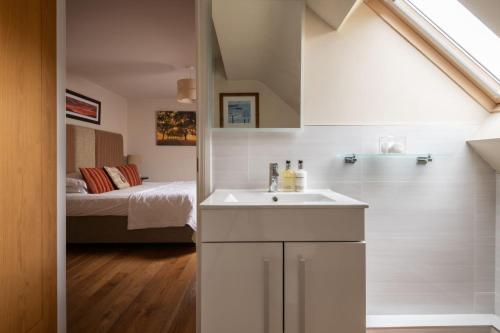 a bathroom with a sink and a bed in a room at The Dinney Holiday Cottages in Bridgnorth