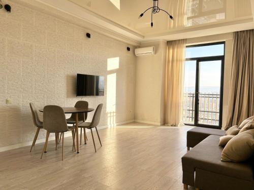 a living room with a table and chairs and a couch at Sunny apartment in Tbilisi City