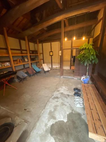 an empty room with chairs and a potted plant at dannouraしげの里 1棟貸切 築120年古民家 バーベキュー 海が見える in Takamatsu