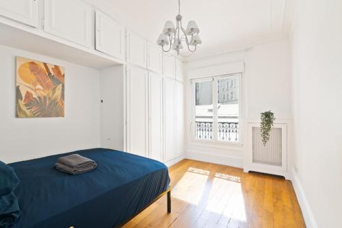 Una habitación blanca con una cama y una ventana. en Arc de Triomphe - Luxurious 3 Bedroom with NetFlix, en París