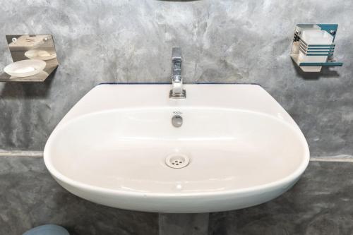 a white sink in a bathroom with a counter at Barramundi in Puttalam