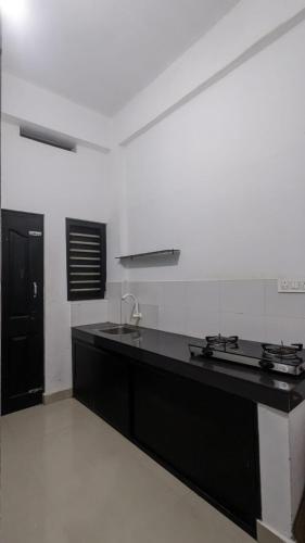 a kitchen with a black counter top and a black door at Anam residence in Tāzhekkod