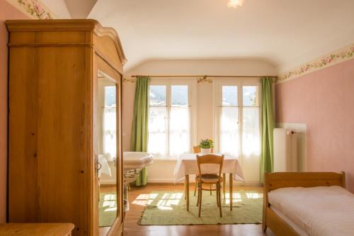 a bedroom with a table and a bed and a room at Historic Hotel Falken in Wengen