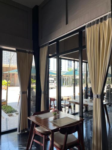 a table and chairs in a room with windows at The Quadrant Hotel KNO in Medan