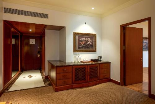a room with a wooden dresser and a mirror at The Orchid Hotel Mumbai Vile Parle in Mumbai