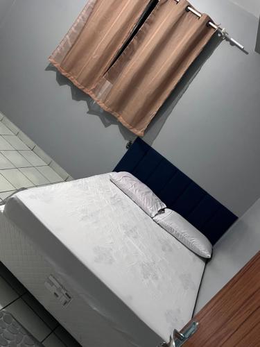 a bed in a room with a window at Casa da folha 12 in Marabá
