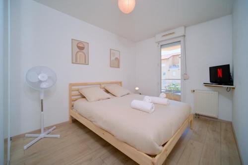 a bedroom with a bed with a fan and a window at Bright, 2 bedrooms, central, garage and balcony in Condrieu