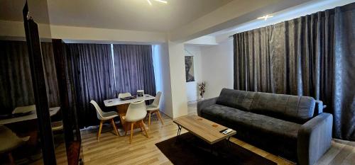 una sala de estar con un sofá y una mesa en Loft Craiova Apartament, en Craiova