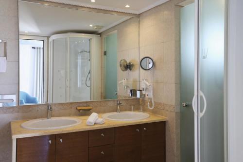 a bathroom with two sinks and a large mirror at Poseidon Hotel Suites in Mýkonos City