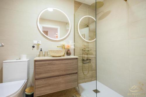 ein Bad mit einer Dusche, einem WC und einem Spiegel in der Unterkunft Le Solarium Campoamor in Orihuela