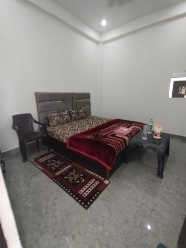a bedroom with a large bed with a table at Hotel AV Palace Near Ram Mandir Ayodhya in Ayodhya