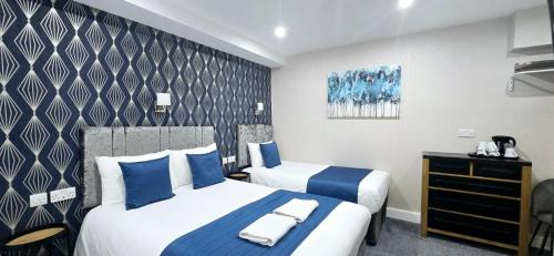 a hotel room with two beds with blue pillows at George Hotel in London