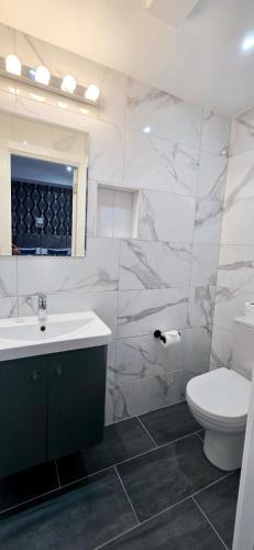 a bathroom with a sink and a toilet and a mirror at George Hotel in London