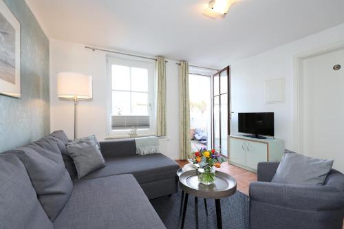 a living room with a couch and a tv at Appartementhaus Strandnähe in Warnemünde