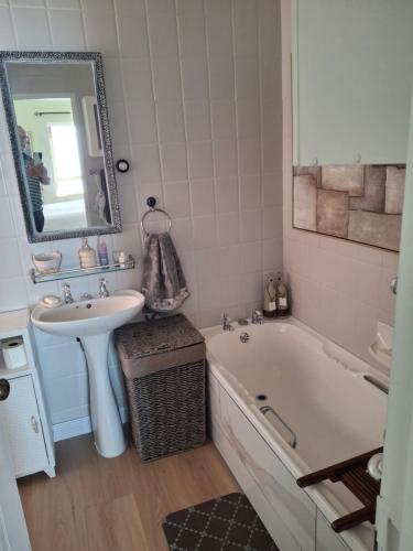 a bathroom with a sink and a bath tub and a sink at Notre Petit Paradis in Mossel Bay