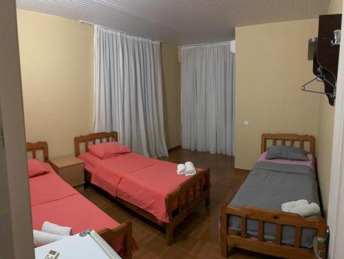 two beds in a room with red sheets at HOTEL Mare in Ureki