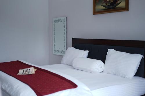 a bed with white pillows and a red blanket on it at Jags-N-Kals in Bhīm Tāl