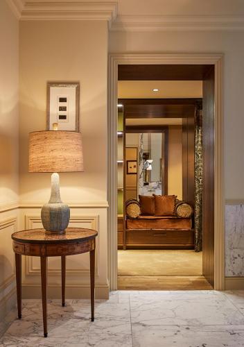 a living room with a table and a couch in a mirror at De L’Europe Amsterdam – The Leading Hotels of the World in Amsterdam