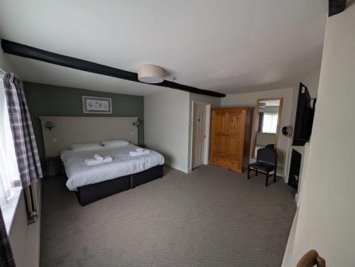 a bedroom with a bed and a ceiling fan at The Bull Hotel in Downton