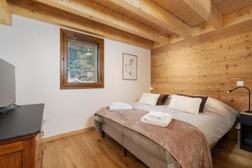 a bedroom with a bed in a room with wooden walls at Alpium, Morzine centre, 5 personnes in Morzine