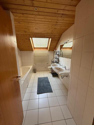 a bathroom with a skylight and a tub and a sink at Ferienwohnung AA-Waldhausen OG in Aalen