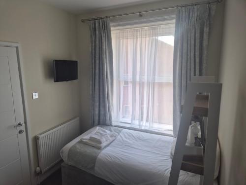 a small bedroom with a bed and a window at Grand Hotel Swanage in Swanage