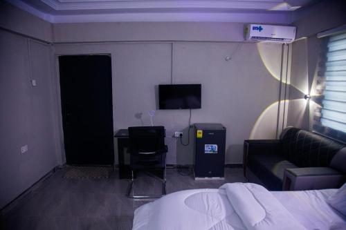 a bedroom with a bed and a desk and a television at Peace Star Hotel in Wa