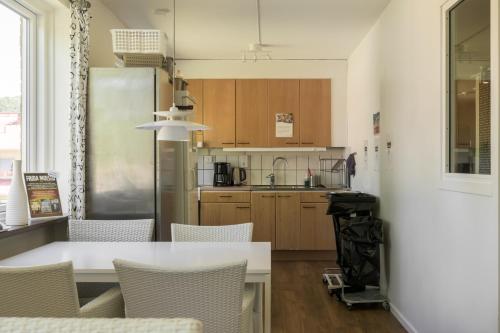 a kitchen with a table and chairs and a refrigerator at Huskvarna Hotell & Vandrarhem in Huskvarna