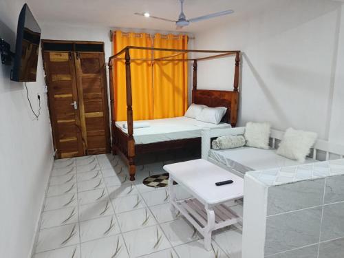 a room with two beds and a tv in it at Watamu Plaza Studio 3 in Watamu