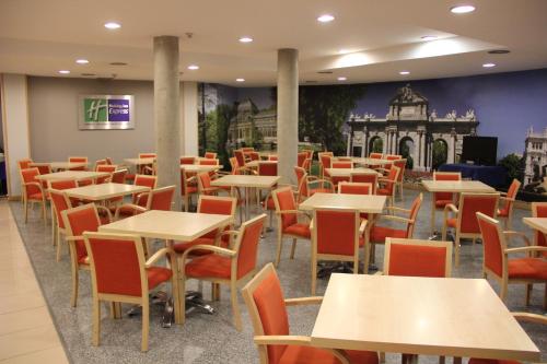 an empty restaurant with tables and chairs at Holiday Inn Express San Sebastian de los Reyes by IHG in San Sebastián de los Reyes