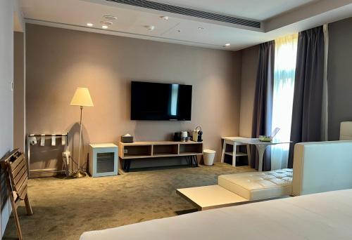 a living room with a flat screen tv on the wall at 秐朗文旅AKA Hotel in Taipei