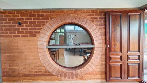 a brick wall with a circular mirror on it at Savana Stay in Puducherry