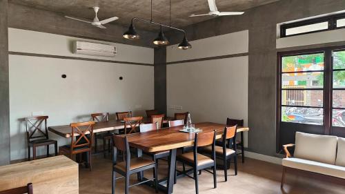 a dining room with a wooden table and chairs at Savana Stay in Puducherry