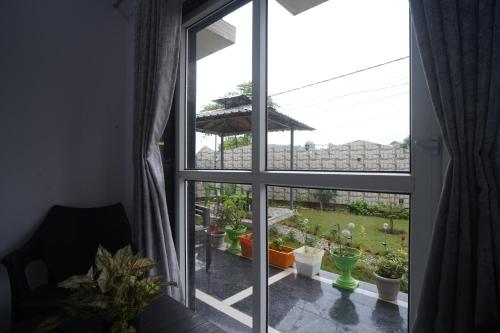 an open window with a view of a garden at Jags-N-Kals in Bhīm Tāl