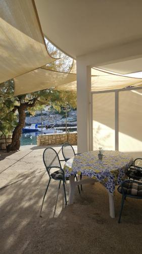 a table and chairs in a room with a view of a boat at Apartment Karuza Rukavac in Vis