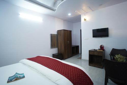 a hotel room with a bed and a television at Jags-N-Kals in Bhīm Tāl