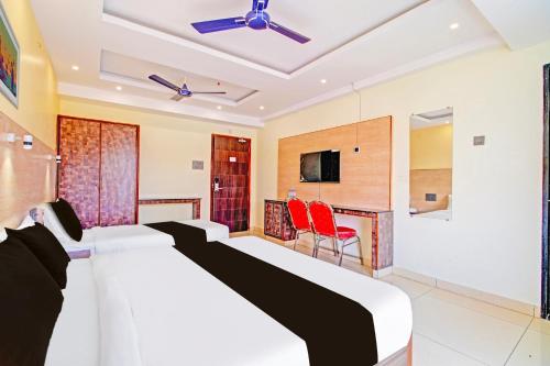 a hotel room with a bed and a tv at Super Collection O Grand Governorpet in Vijayawada