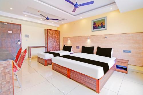 a hotel room with two beds and a kitchen at Super Collection O Grand Governorpet in Vijayawada