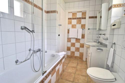 a bathroom with a tub and a toilet and a sink at La Villa in Montreux