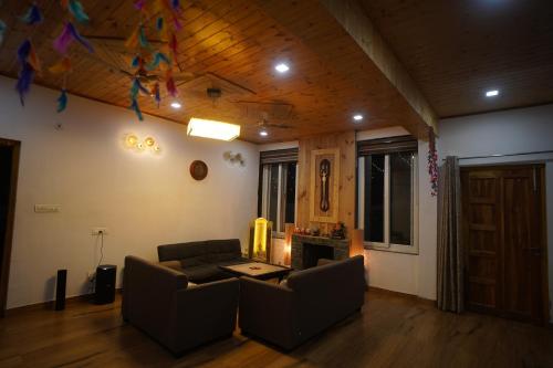 a living room with a couch and a table at Jags-N-Kals in Bhīm Tāl