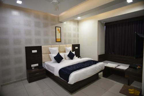 a bedroom with a king sized bed with a desk at Hotel Royal Residency in Vadodara