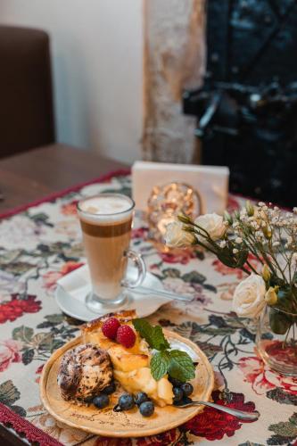 a table with a plate of food and a cup of coffee at Zamek Czocha in Leśna