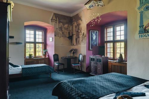a bedroom with two beds and a desk and windows at Zamek Czocha in Leśna