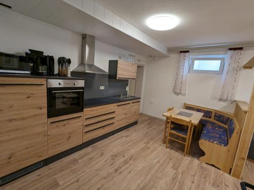 a kitchen with wooden cabinets and a table in it at Souterrainwohnung in Kelheim