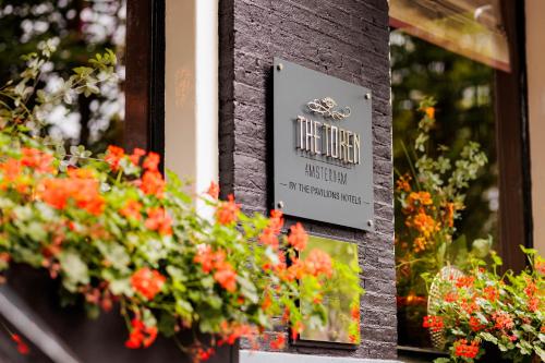 a sign for a flower shop with red flowers at The Pavilions Amsterdam, The Toren in Amsterdam
