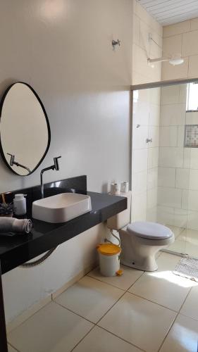 a bathroom with a sink and a toilet and a mirror at Casa Viva Bonito in Bonito