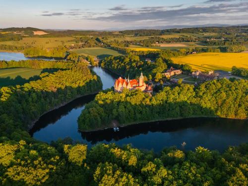 an aerial view of a castle on an island in a lake at Zamek Czocha in Leśna