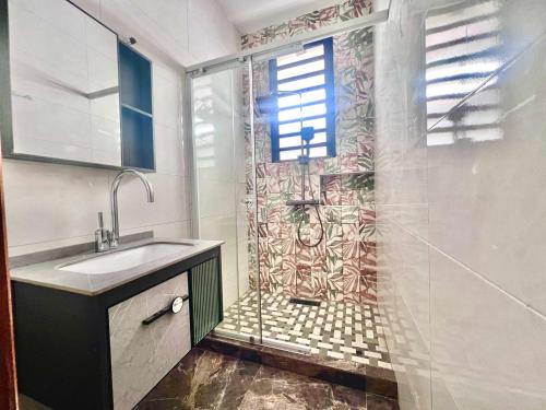 a bathroom with a shower and a sink at Appart Nouvelle Ville Toamasina in Toamasina