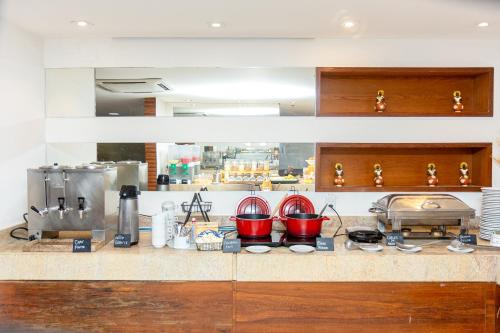 a kitchen counter with red pots and pans on it at Salvador Business & Flat by Avectur in Salvador